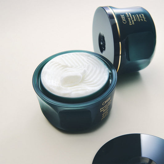 Open jar of cream with visible brand name on a light background