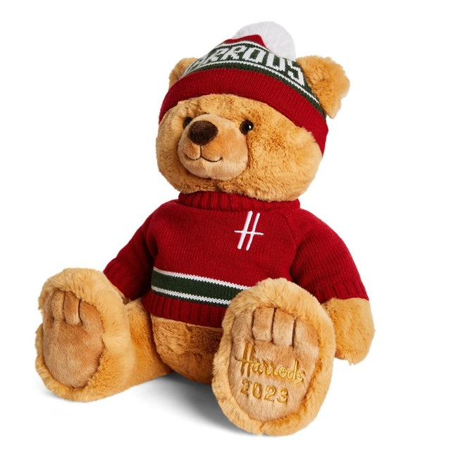 Angled view of 2023 Harrods Ethan Christmas teddy bear in red knit outfit, Harrods 2023 paw detail