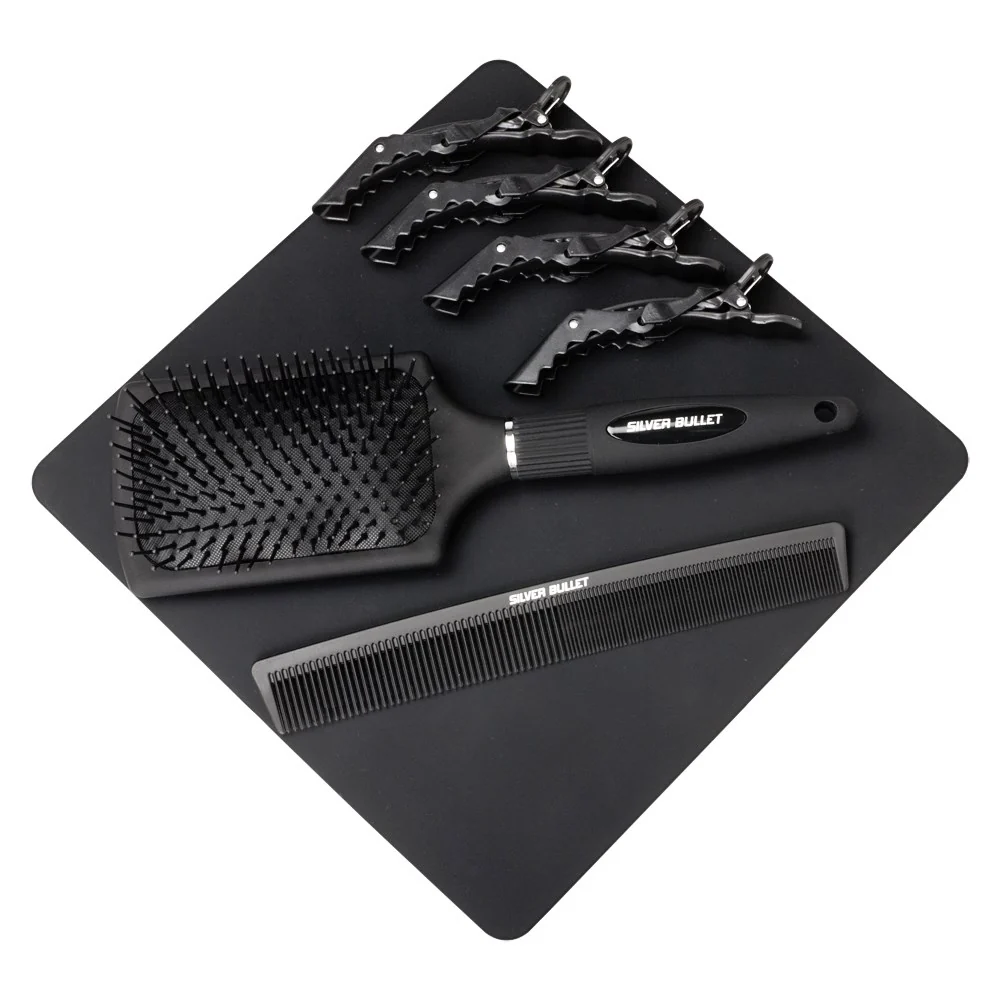 A black hair styling set on a black mat, including a paddle brush, a wide-tooth comb, and five hair clips, with the brand name 'SUPER BAILLET' visible on the tools.