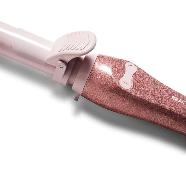 Close-up of Beachwaver S1 Glitter Holiday 25mm curling iron barrel and clamp in pink sparkle