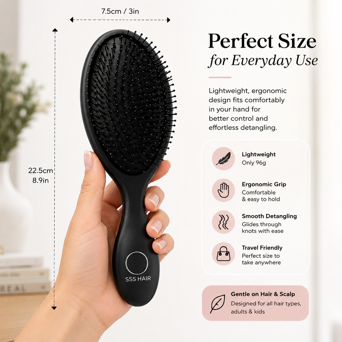 Black hairbrush held by a hand with product details on a light background