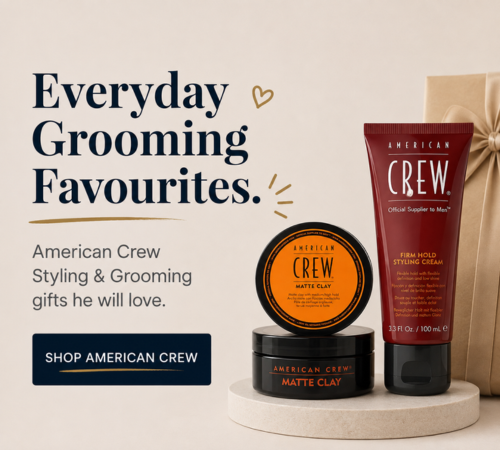 American Crew grooming gift set featuring a matte clay jar, a firm hold styling cream tube, and a gift box on a pedestal with promotional text.