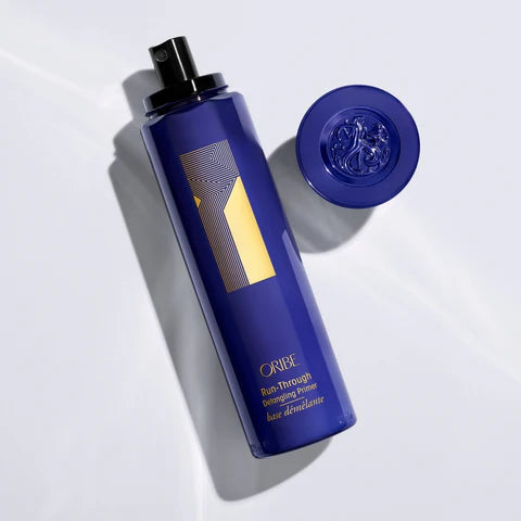 Blue Oribe hair product bottle with gold label on a white background