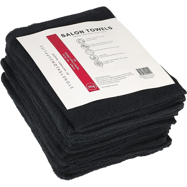 Stack of black 95g cotton salon towels, 40x70cm, pack of 10 with product label on top