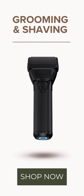 A black electric grooming device centered on a light beige background, with the text 'GROOMING & SHAVING' at the top and a green 'SHOP NOW' button at the bottom.