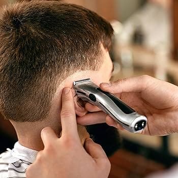 Barber using Wahl Beret cordless silver trimmer to edge a client’s haircut